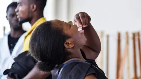 A woman takes the oral cholera vaccine at a temporary treatment centre in Lusaka