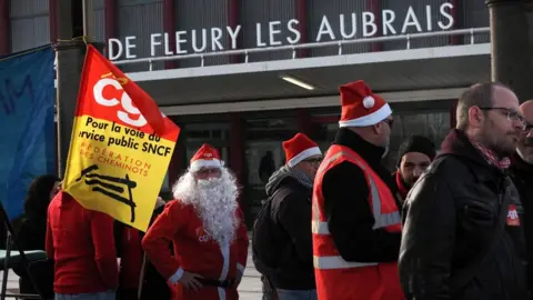 Getty Images SNCF railway workers serve Christmas dinners in front of the Les Aubrais station near Orleans, central France, 23 December 2019