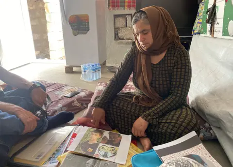 Bahar looks at pictures of her missing husband and son, now presumed murdered
