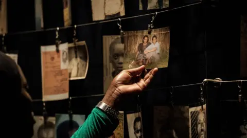 Reuters This file photo taken on April 29, 2018 shows a visitor looking at victims" portraits at the Kigali Genocide Memorial in Kigali, Rwanda