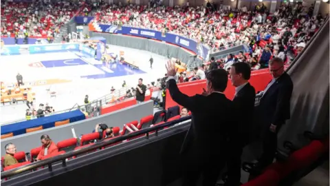 Getty Images US Secretary of State Antony Blinken (L) waves next to US Ambassador to China Nicholas Burns (C) and US Consulate General in Shanghai Scott Walker (R) while attending a basketball game between the Shanghai Sharks and the Zhejiang Golden Bulls at the Shanghai Indoor Stadium in Shanghai on April 24, 2024