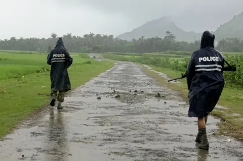 EPA Myanmar police officers patrol a road in northern Rakhine, 26 August