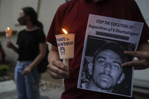 EPA An activist holds a placard outside the Singaporean embassy in Kuala Lumpur, Malaysia, on 8 November 2021