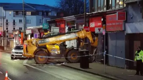 Twitter/@MarkTee83 Digger crashed into shop
