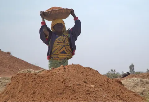 A child carries earth at the Barkin Ladi mind