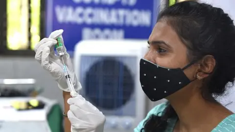 Getty Images A health worker prepares a dose of Covishield vaccine in Delhi