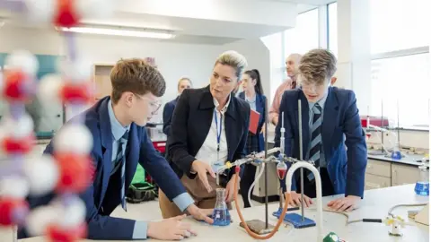 Getty Images Teacher with pupils in science lab