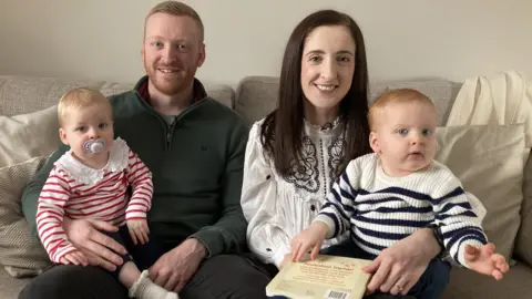 Family photos Bethan Dyke, her husband Craig and their twins on a settee a home