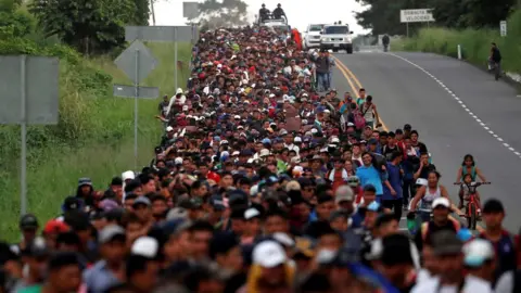 Reuters Migrants, part of a caravan travelling from Central America en route to the US, walk by the road that links Ciudad Hidalgo with Tapachula, 2 November 2018