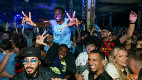 PA Media Manchester City fans celebrate at the Depot Mayfield in Manchester
