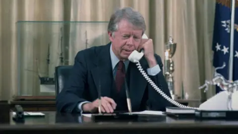 HUM Images Jimmy Carter makes a phone call at his desk in the Oval Office