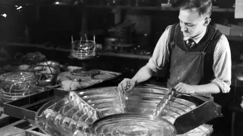 Inpho A worker making the glass prisms for the lighthouses