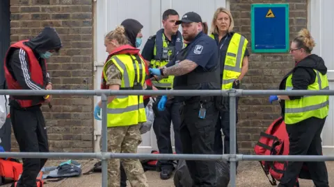 Getty Images Military and Border Force with migrants at Dover