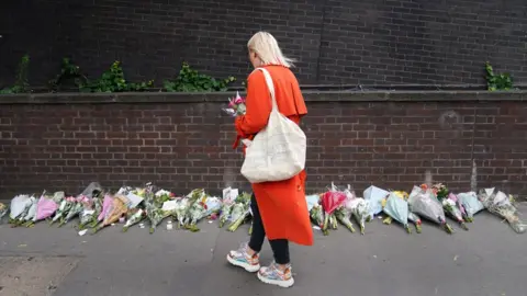PA Media woman putting flowers
