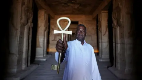 Mohamed Abd El Ghany/Reuters Egyptian temple guard Abd El-Sayed holds the Key of the temple to lock it after the end of the visit to the temple ruins from the 3200-year-old Abu Simbel temple, at the upper reaches of the River Nile in Aswan, Egypt - Monday 1 May 2023