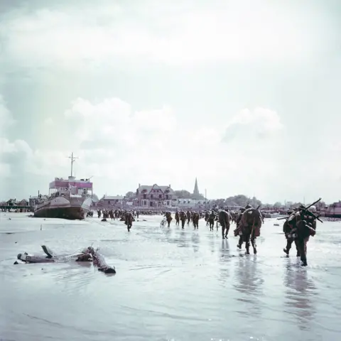 Getty Images Canadian troops walk ashore at Bernières-sur-Mer