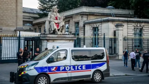 EPA Authorities stand around the statue of Jean-Baptiste Colbert, vandalised by an activist