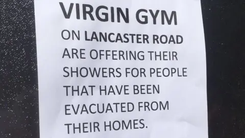 A sign offering local gym showers for those who have been evacuated from their homes