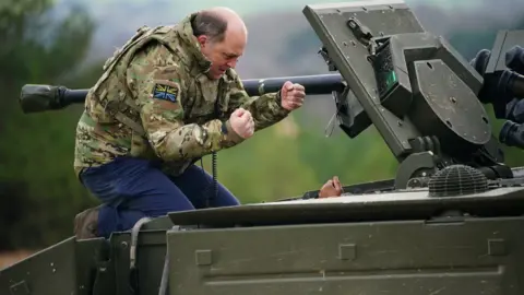 Reuters Defence Secretary Ben Wallace speaks to the crew inside an Ajax armoured personnel carrier after a demonstration during a visit to Bovington Camp military base in Dorset