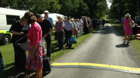 The queue of visitors stretches down the avenue leading to Helmingham Hall