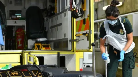 PA Media A paramedic cleans down equipment in the ambulance decontamination area outside the Respiratory Assessment Unit