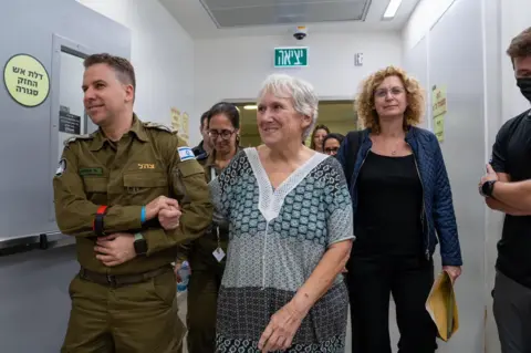 Israel Defense Forces Margalit Mozes being supported by an Israeli soldier after her release