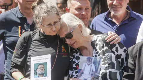 PA Media Families embrace outside Central Hall in Westminster, London, after the publication of the Infected Blood Inquiry