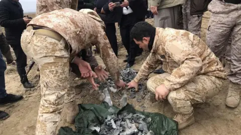 Getty Images Iraqi security forces find and collect the pieces of missiles