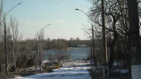 BBC/Dave Bull The Dnipro river, seen down a street in Kherson