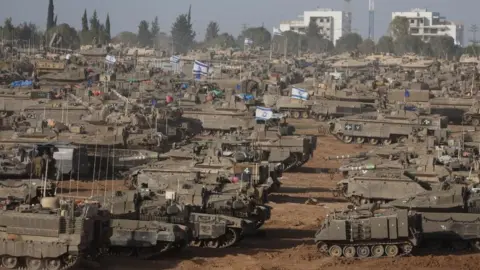 EPA Israeli tanks and other armoured vehicles gather near the Gaza border fence on 9 May 2024
