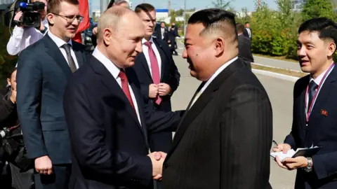 Reuters Vladimir Putin shakes hands with Kim Jong Un as the two leaders are reunited in a meeting at Vostochny Cosmodrome in Russia's far east, 13 September 2023