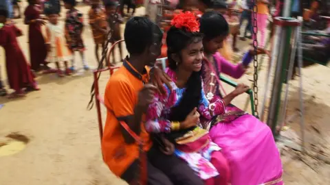 Young Rohingya refugees enjoy ride in a carousel during Eid Al-Adha festival celebrations at the Kutupalong refugee camp in Ukhia district near Cox"s Bazar on August 23, 2018. - Nearly one million Rohingya Muslims marked Eid al-Adha on Wednesday in the world"s largest refugee camp, almost a year to the day since a brutal military crackdown drove the persecuted minority from Myanmar in huge numbers