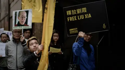 Getty Images people with photograph of Liu Xia and Amnesty International placard saying Free Liu Xia