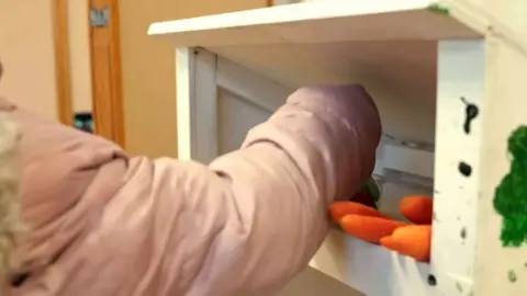 A child grabs a carrot