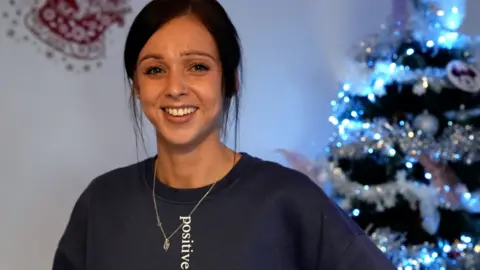 Charlotte Chapman stood in front of a Christmas tree