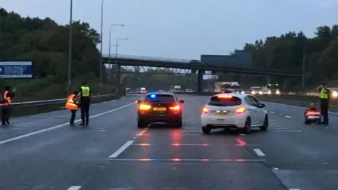 Essex Police Police on the M25 with Insulate Britain protesters.