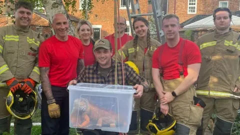 LFRS Fire crews with the saved iguana in a box