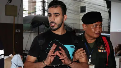 Reuters Hakeem Al-Araibi is held by Thai security officials as he arrives in court in Bangkok in December