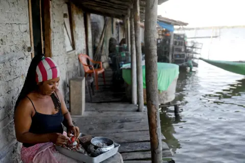 Nacho Doce / Reuters Vandeka, wife of fisherman Jose da Cruz, peels crabs