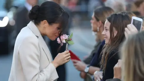 AFP Meghan handed a flower by a girl