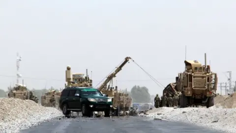 EPA soldiers work to remove the damaged vehicle from the roadway