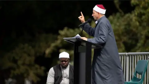 AFP/Getty Images Gamal Fouda, the imam (lead cleric) of tragedy-stricken Al Noor mosque, delivers a sermon ahead of a two-minute observation of silence for victims of the twin mosque massacre, during congregational Friday prayers and memorial gathering at Hagley Park in Christchurch on March 22, 2109.