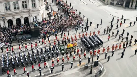 PA Media The State Gun Carriage carries the coffin of Queen Elizabeth II, draped in the Royal Standard with the Imperial State Crown and the Sovereign's orb and sceptre, as it leaves Westminster Abbey after the State Funeral of the Queen.