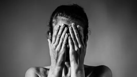 Getty Images Woman with hands over face