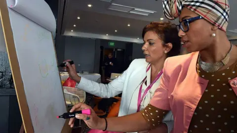 Getty Images Ms Abdel-Magied stands with a federal MP, Anne Aly, at a summit in 2015