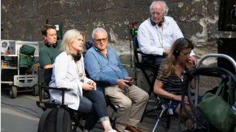 Bad Wolf Jane Tranter (second from left) and author Philip Pullman (second from right) on location while filming His Dark Materials