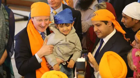 PA Media Samir Jassal (right) with former Prime Minister David Cameron
