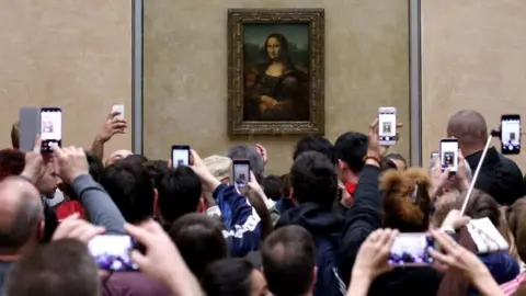 Getty Images Visitors take pictures of the Mona Lisa by Leonardo Da Vinci, at the Louvre Museum in Paris