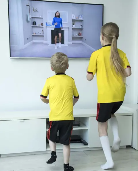 PA Media Two children take part in "PE with Joe" a daily live workout with Joe Wicks on Youtube