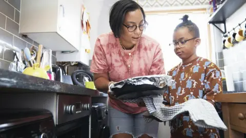 Getty Images A mother and son prepare to put a dish in the oven